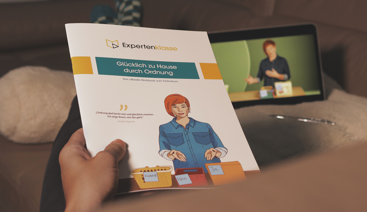 Workbook halten auf Sofa während Onlinekurs schauen